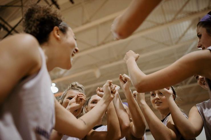 Asbury University women's basketball team in a huddle ready to play