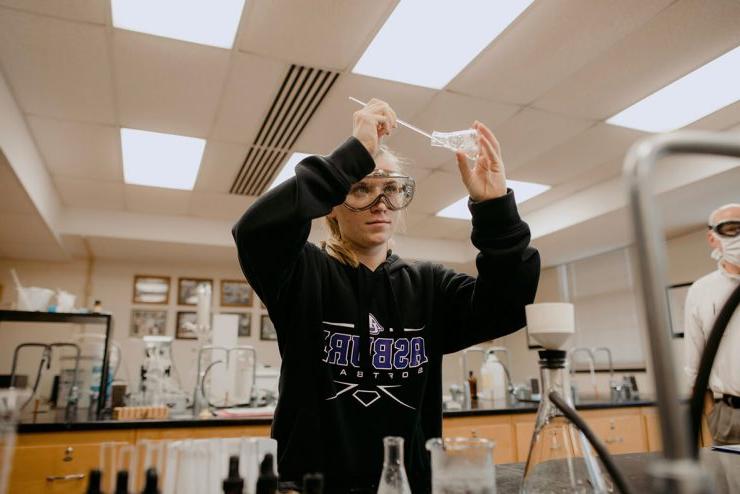 An Asbury University Undergraduate student uses a beaker in a science lab